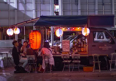 People throng to the food carts for deep fried skewers and drinks at night